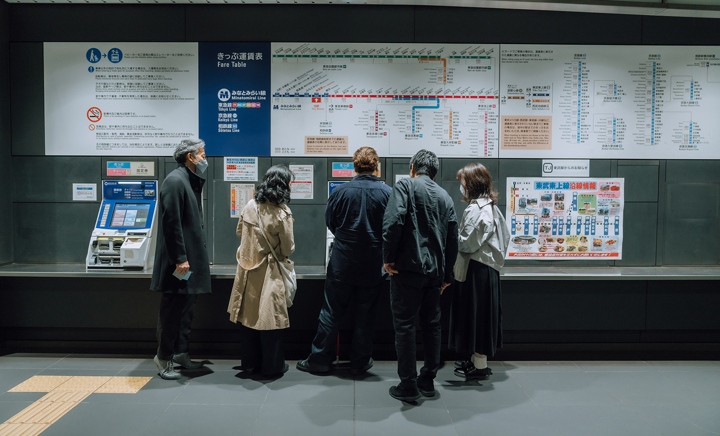 The lead user is buying a ticket at a ticket vending machine