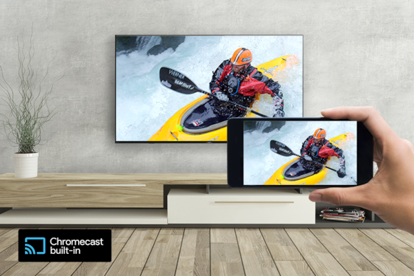 A hand holds a smartphone in front of a wall-mounted TV - both screens display the same kayaking image. A logo for Chromecast built-in sits on the bottom left.